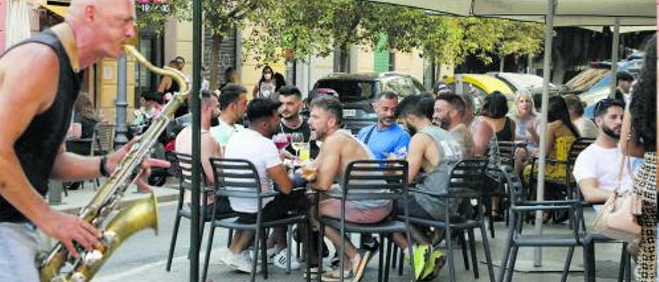 Un músico toca en una terraza llena de gente en València.