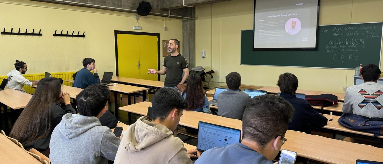 Ángel García, de pie, en el aula de la Complutense, durante su intervención.