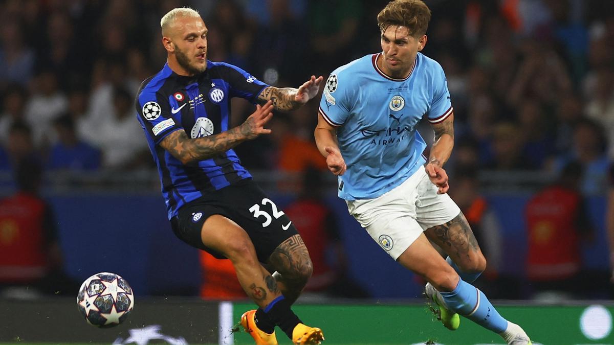 John Stones supera a Federico Dimarco en un lance del partido.