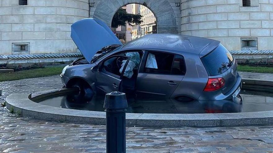 El coche, dentro de la fuente de Puerta de Palmas, esta mañana.