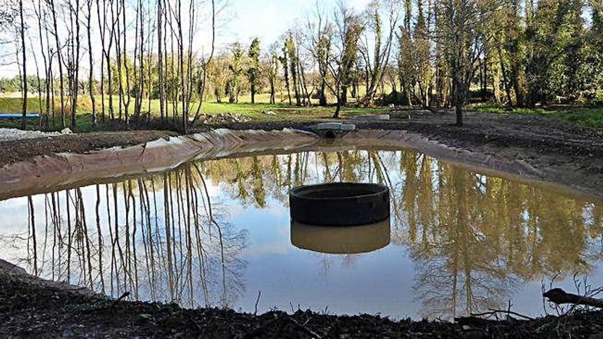 Una de las balsas de agua en la zona de obras de la urbanización, al borde del regato Fonte de Xaz.