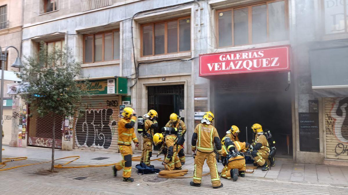 Einsatzkräfte der Feuerwehr am Eingang der Galerías Velázquez in Palma.