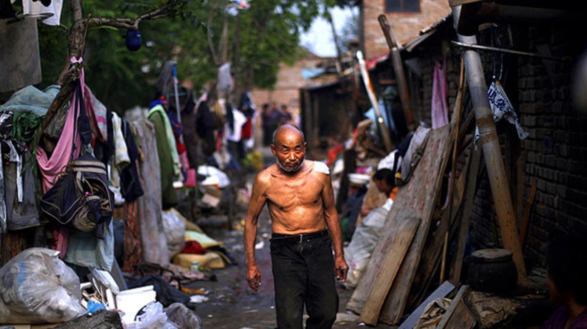 Un avi camina per una zona pobra de Pequín, Xina.