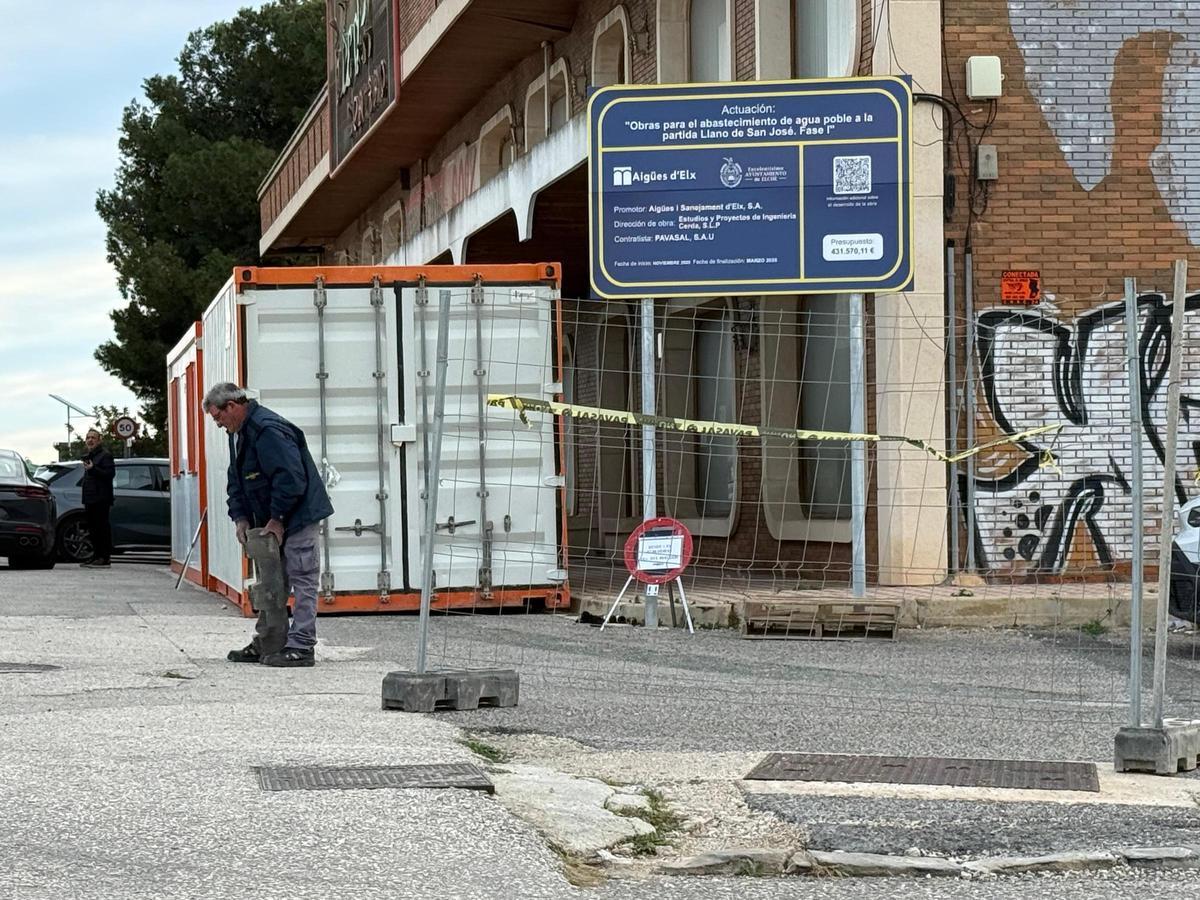 Operarios con el cartel de las obras que ya se ha instalado en la zona.