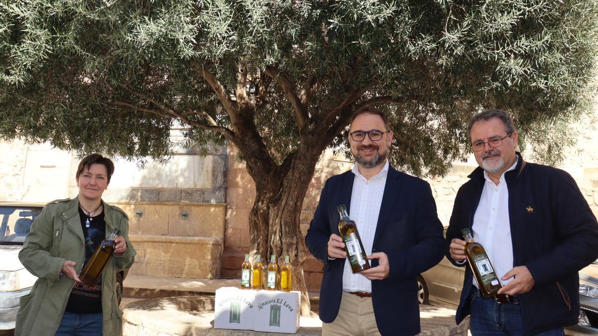 María Dolores Chumilla, Diego José Mateos y Antonio Navarro, con el aceite de los olivos municipales como el que se situaba detrás de ellos, en la Plaza del Caño.