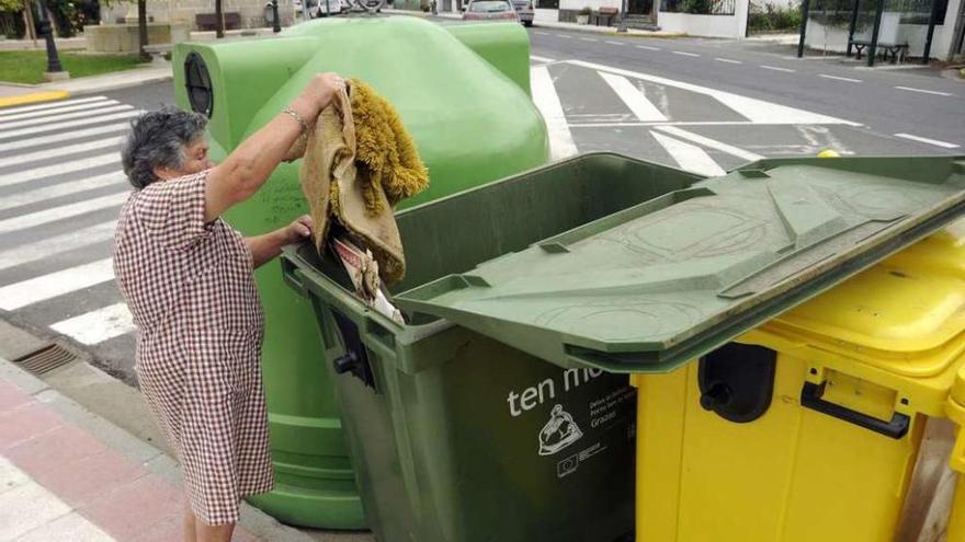 Una vecina deposita basura en uno de los contenedores del casco urbano de Silleda. // Bernabé/Javier Lalín