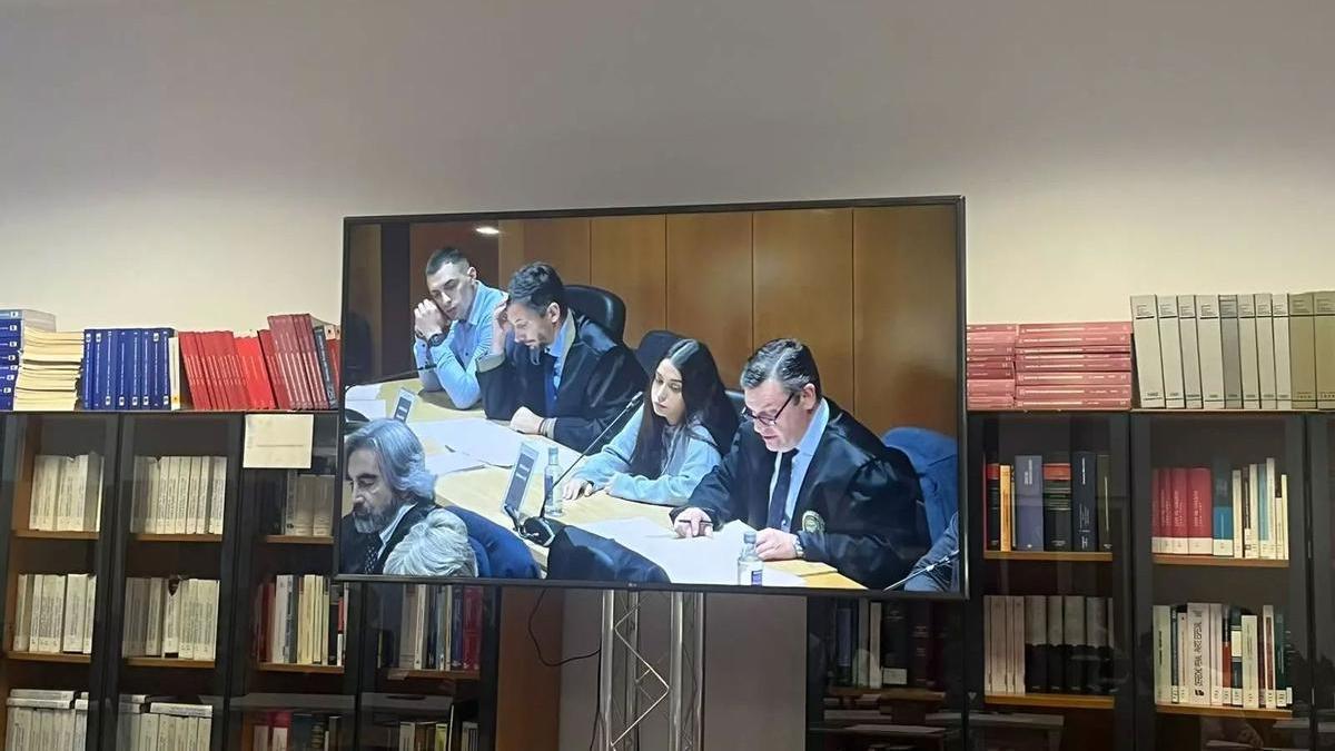 Un monitor en la sala de prensa de la Audiencia de A Coruña muestra a dos de los acusados, Diego Montaña y Catherine Silva, junto a sus abogados hoy en el juicio del caso Samuel Luiz.