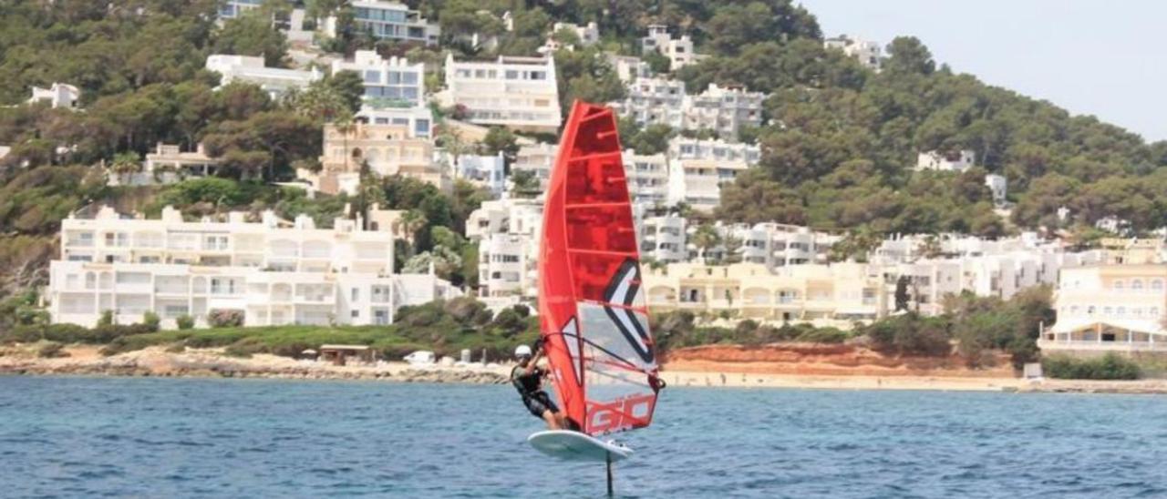 Imagen de un windsurfista con su tabla en aguas de Eivissa.