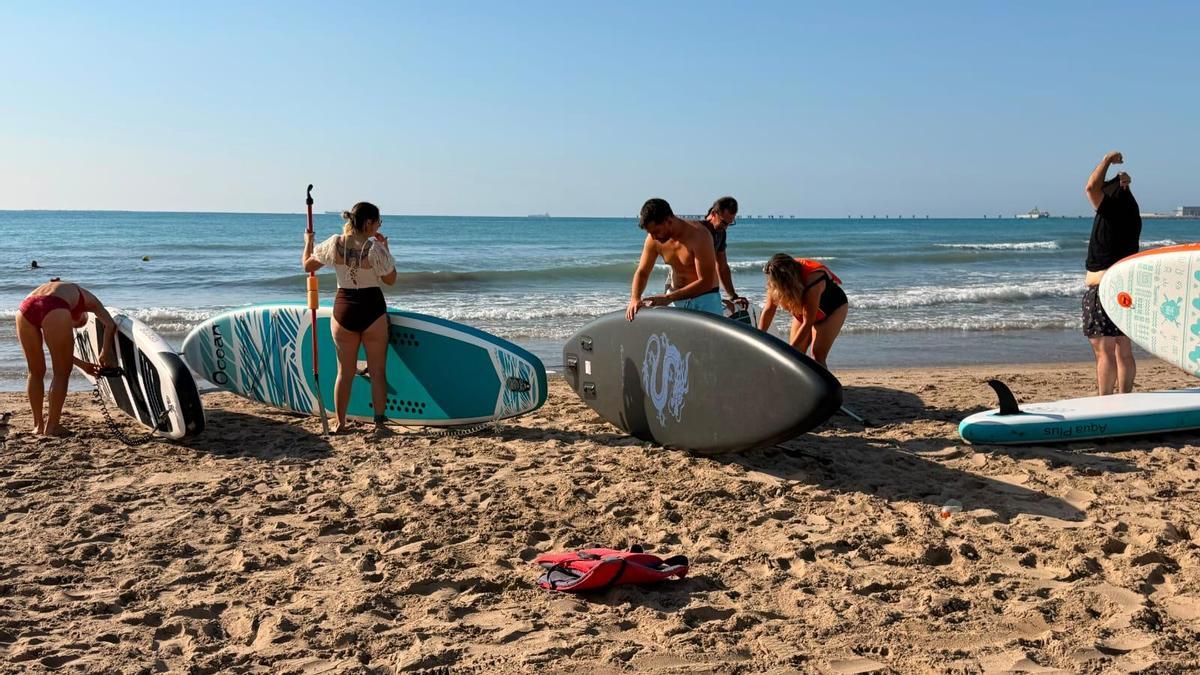 Varias personas cogiendo las tablas, esta tarde.