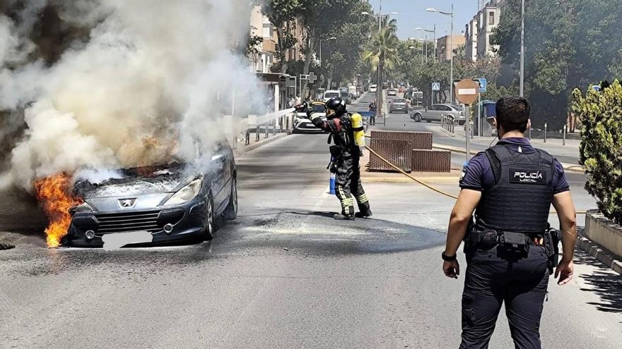 Actuación de bomberos y Policía Local de Puente Genil para apagar el coche en llamas.