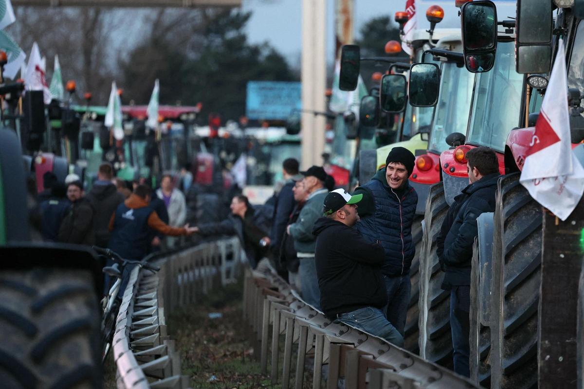 Agricultores charlan junto a sus tractores durante una protesta en Francia.