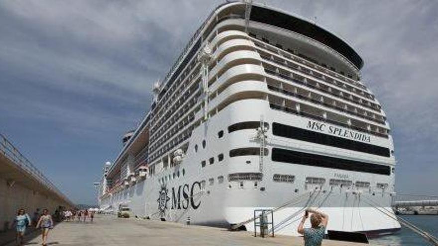 Una turista fotografía un crucero de gran tamaño amarrado en el puerto de Ibiza.