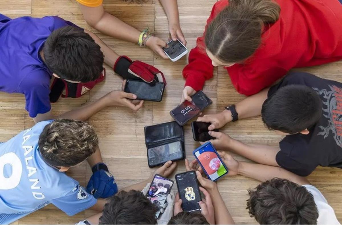 Mainada fent servir dispositius mòbils.