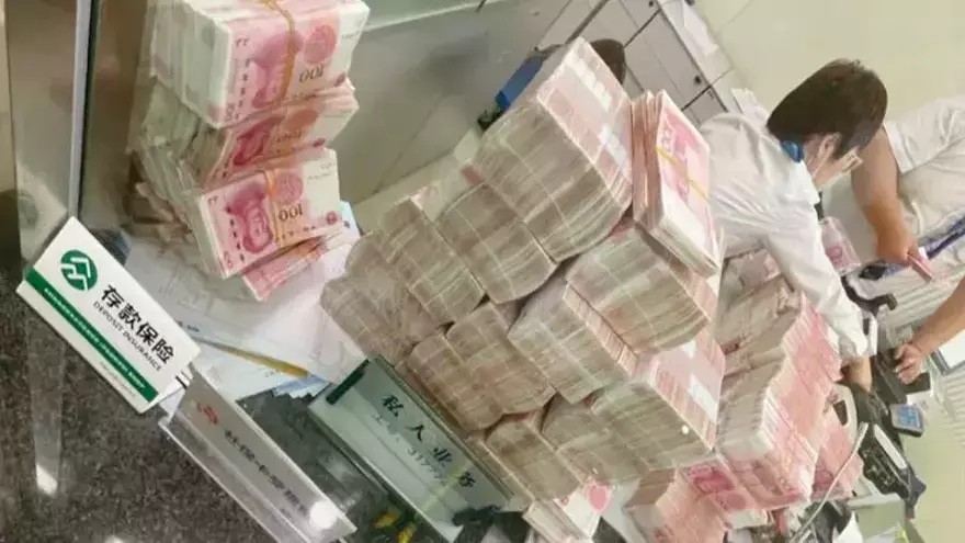 Una empleada del Banco de Shangai, contando el dinero que retiraba &#039;Sunwear&#039;