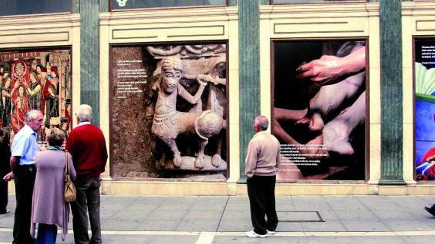 Varios paseantes se paran ante las imágenes de gran tamaño instaladas en el casco histórico de la capital.