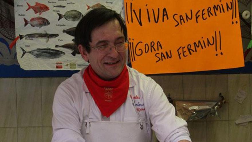 Ambrosio Loinaz atiende a una clienta en su negocio, donde se celebra San Fermín