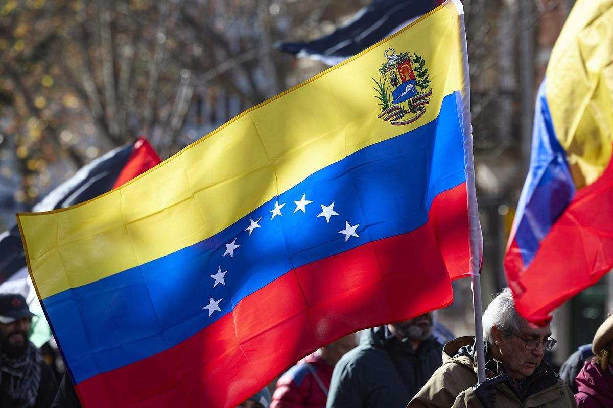 Manifestantes con una bandera de Venezuela.