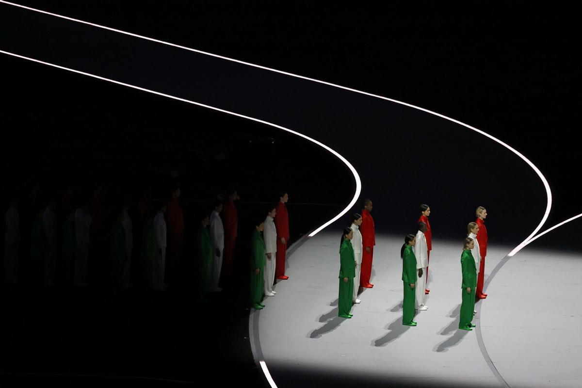 Modelos visten los colores de la bandera italiana, mientras desfilan durante la Ceremonia.