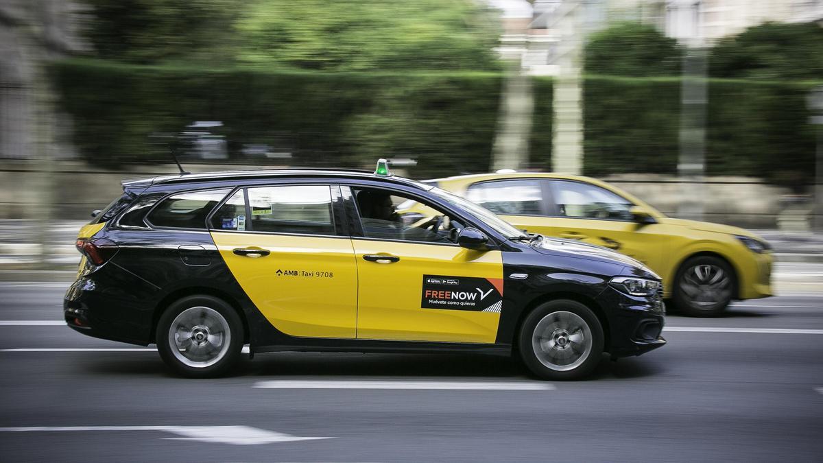 Un taxi con pegatinas de Free Now circula por las calles de Barcelona