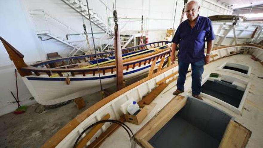 Paco Blasco, miembro de El Caero, junto a dos llauds de 1950 que se están reparando en los astilleros de Astondoa, en Santa Pola.