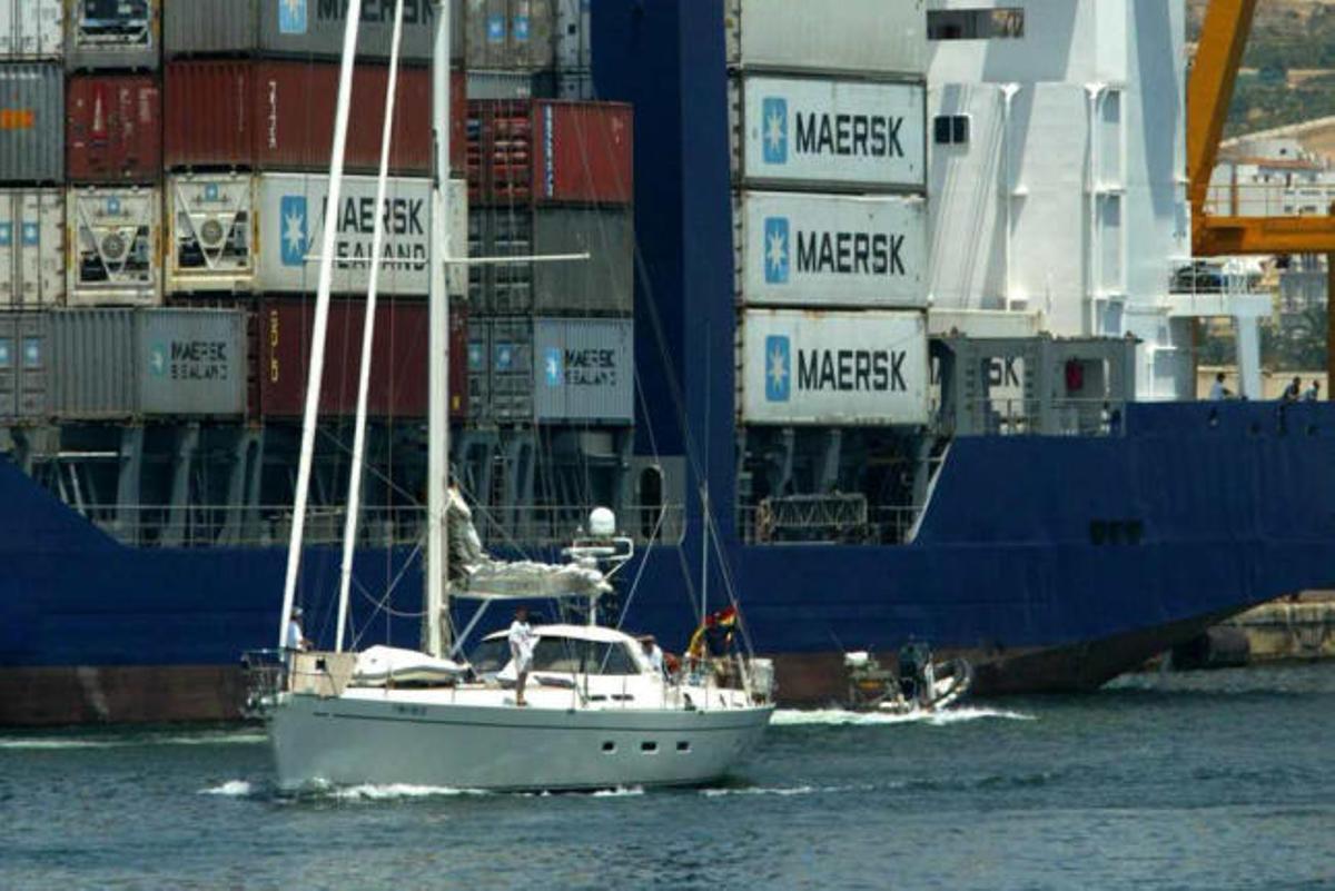 Un embarcación deportiva pasa junto a un barco cargado de contenedores en el Puerto.