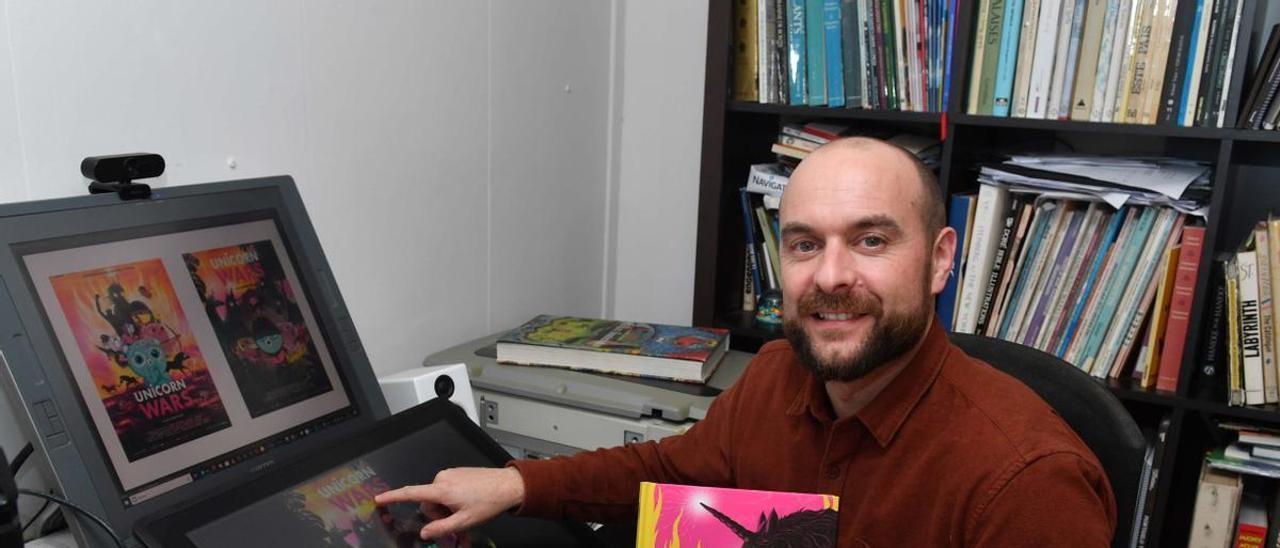 El dibujante Alberto Vázquez, ayer, en su mesa de trabajo, con el libro de arte de ‘Unicorn Wars’.