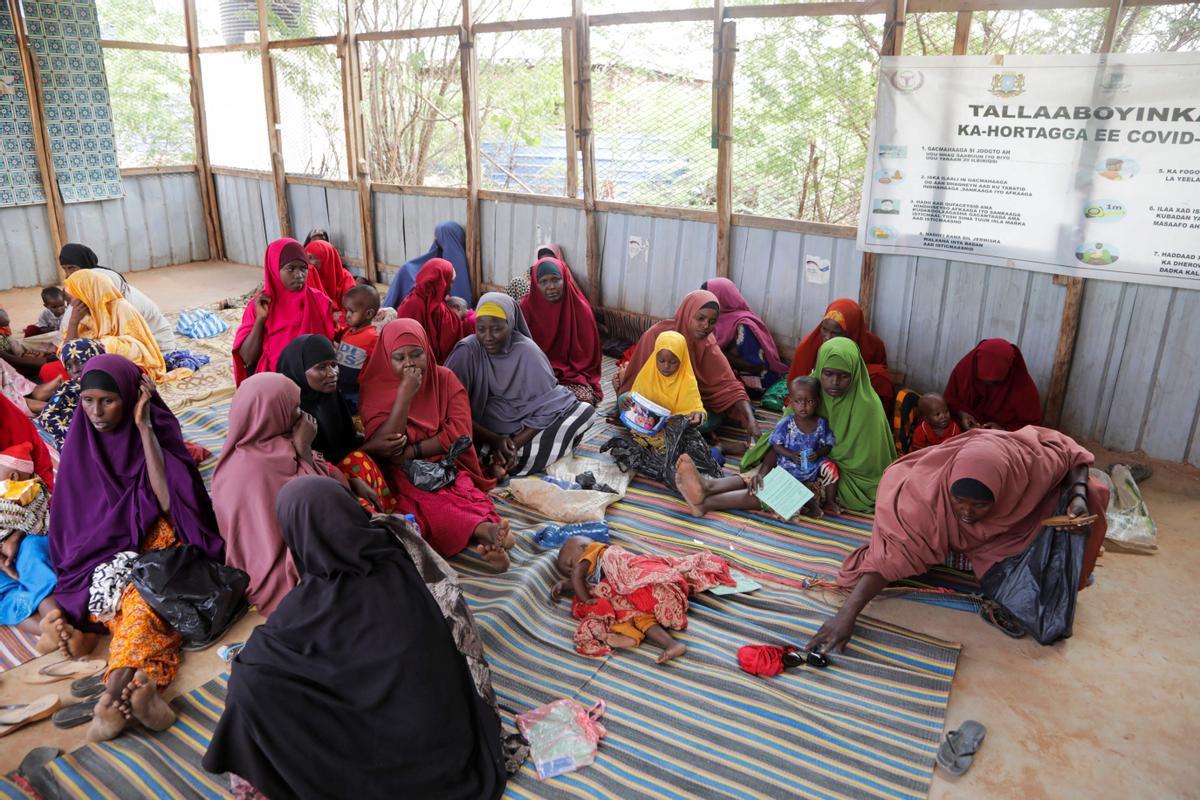 Mujeres somalíes desplazadas internamente se sientan con sus hijos mientras esperan la detección de desnutrición en el hospital Dollow.