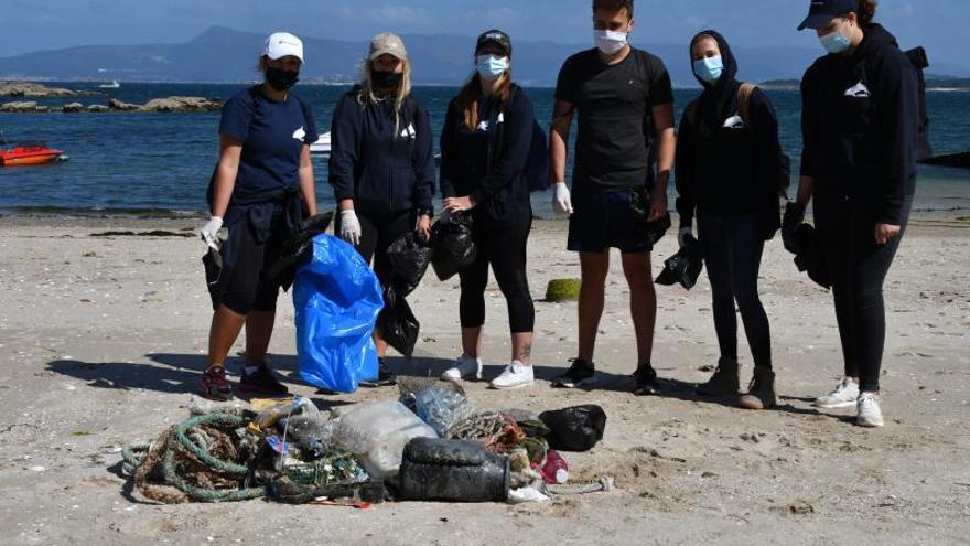 Uno de los grupos participantes junto a los residuos recogidos en una de las playas mecas, ayer.