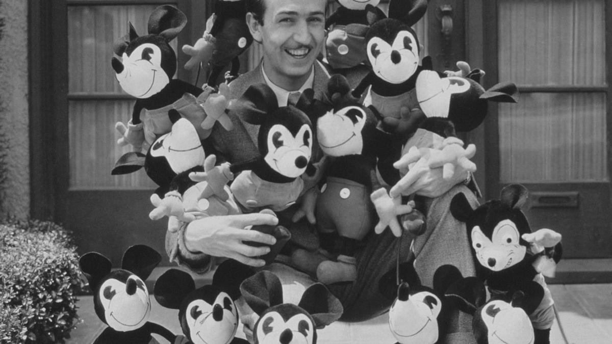 Walt Disney rodeado de peluches de uno de sus personajes más icónicos, Mickey Mouse.