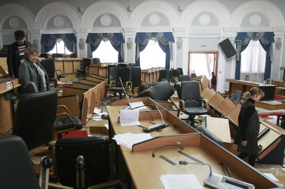 People stand in the vandalised parliament hall in Bixkek