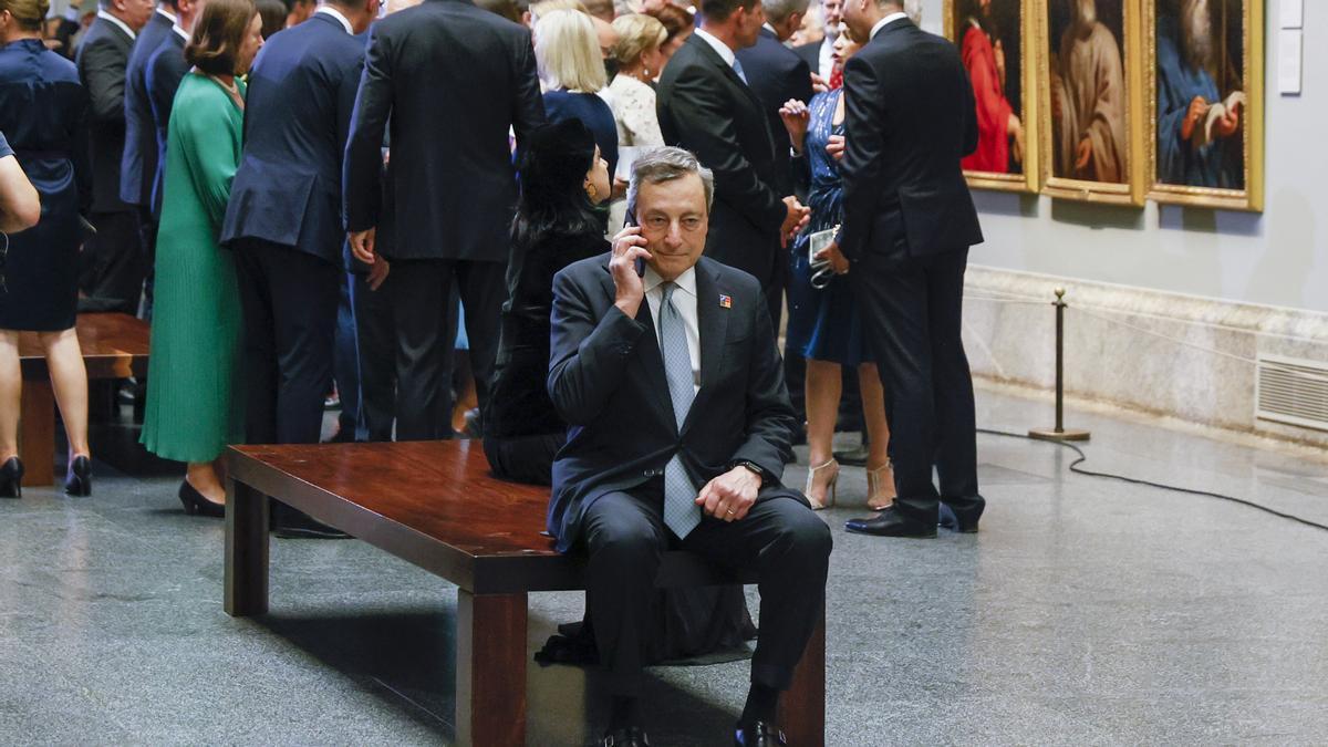 Mario Draghi conversa por teléfono a espaldas de los asistentes a la cena de la cumbre de la OTAN en el Museo del Prado de Madrid.