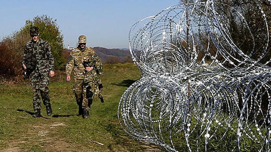 Soldados colocan alambre de espino en la frontera con Croacia.