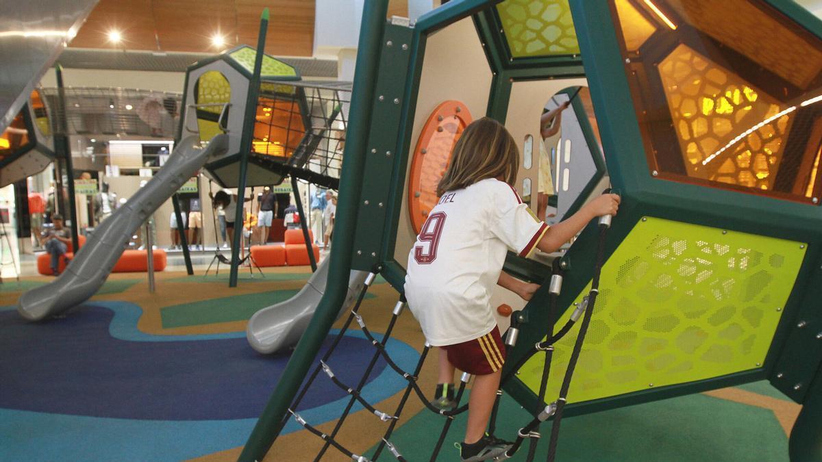 Un niño juega en el parque infantil del centro comercial.