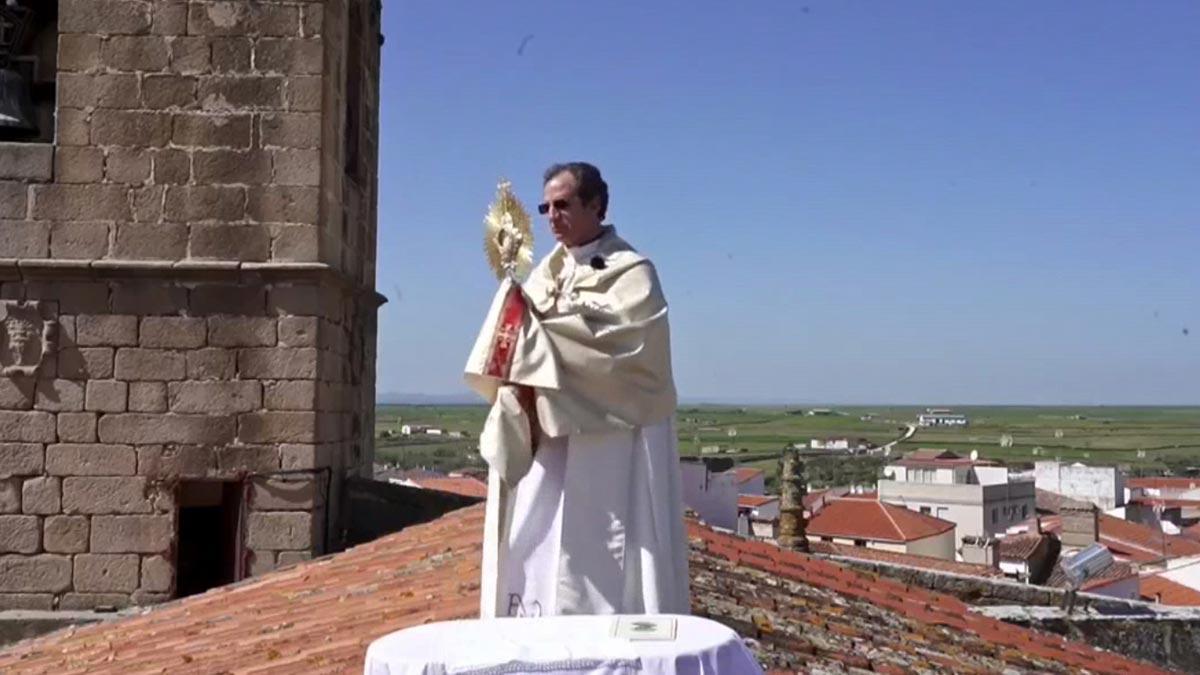 El cura de Arroyo de la Cruz (Cáceres) celebra el corpus desde el tejado de la iglesia.