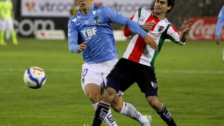 Pablo Hernández (izquierda) pugna por el balón con un rival en un encuentro de la Liga chilena entre O&#039;Higgins y Palestino.