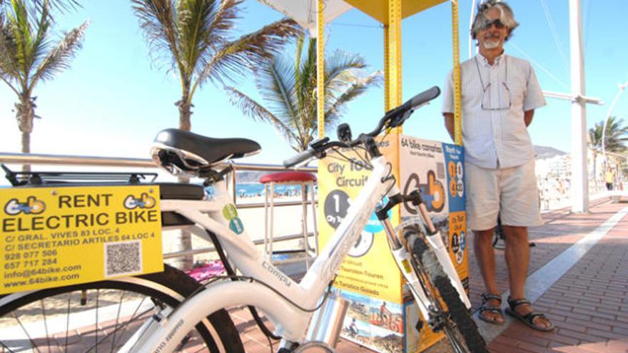 Fernando Artese, propietario de 64 Bike Canarias, muestra las nuevas bicicletas eléctricas en el punto de información del paseo de Las Canteras. | juan carlos castro