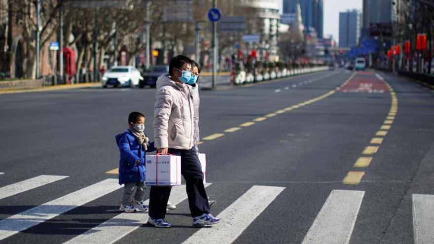 Personas con máscaras, en una zona comercial en el centro de Shanghai.