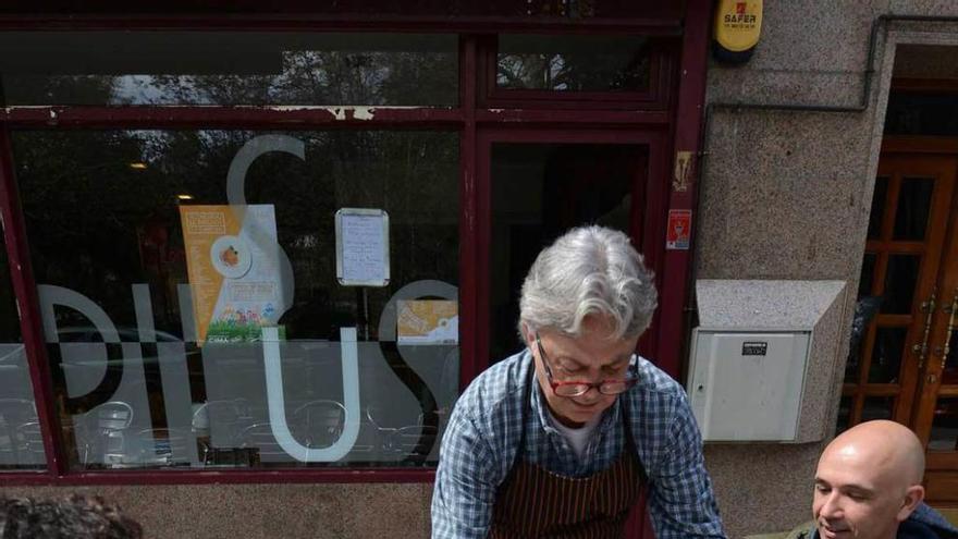 Gaspar Rodríguez, del restaurante Los Pilus, sirviendo unos pinchos en la terraza del establecimiento, en Sama.