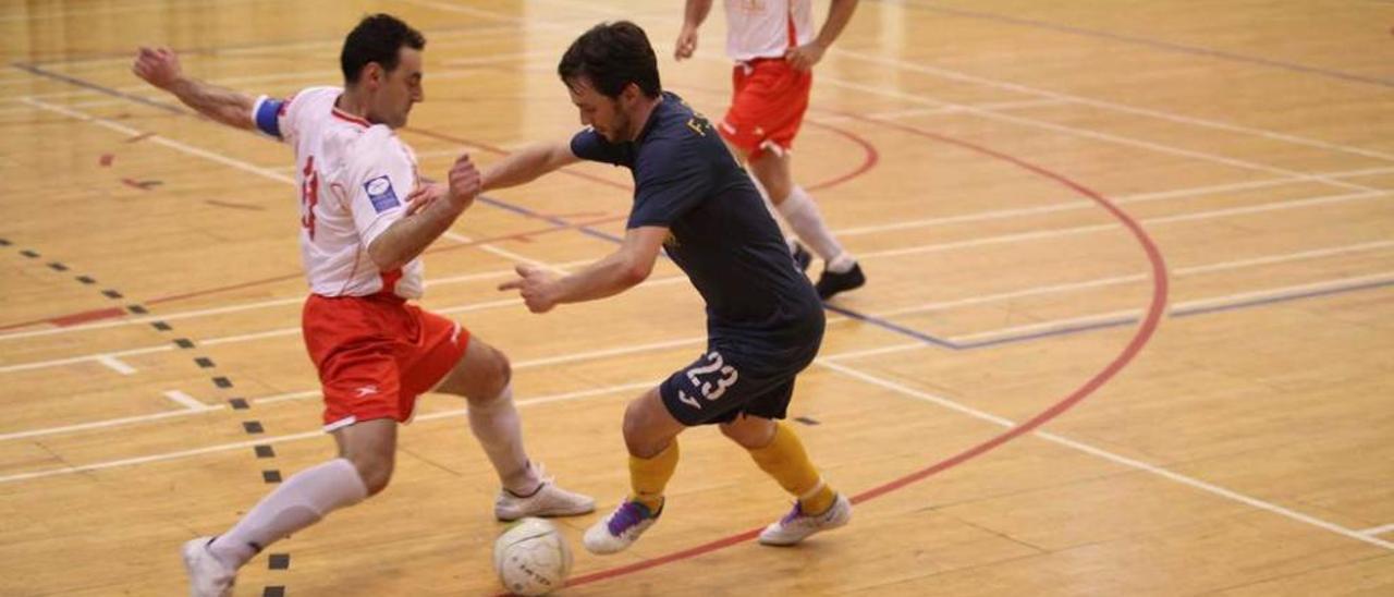 Dos jugadores pugnan por el balón en el partido entre La Tonada y Grado.