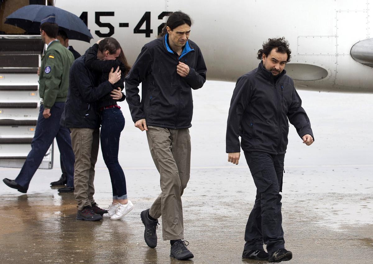 Els periodistes espanyols Ángel Sastre (dreta), José Manuel López (centre) i Antonio Pampliega (abraçant un familiar), a l’arribar aquest matí a la base aèria de Torrejón de Ardoz, a Madrid.