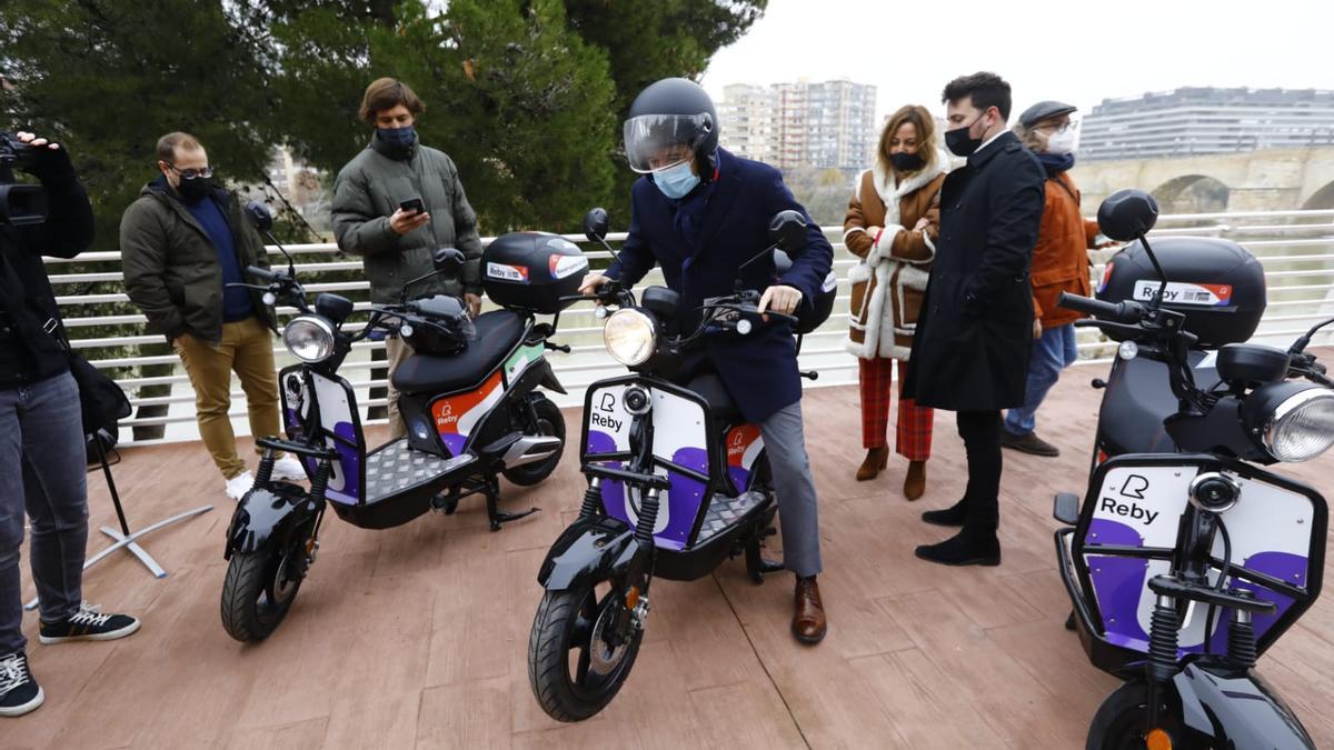 El alcalde de Zaragoza, Jorge Azcón, encima de una de las nuevas motos de Reby, de las que habrá 450 por toda Zaragoza.