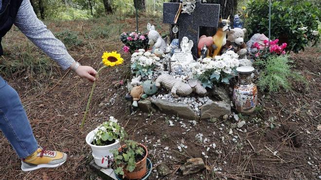 Una persona depositando una flor este lunes en el lugar de la pista forestal de Teo donde fue hallado el cuerpo de Asunta.