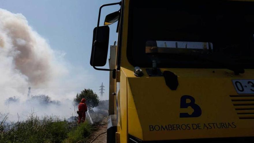 Un bombero, trabajando en los servicios de extinción en una zona cercana a Barredo.