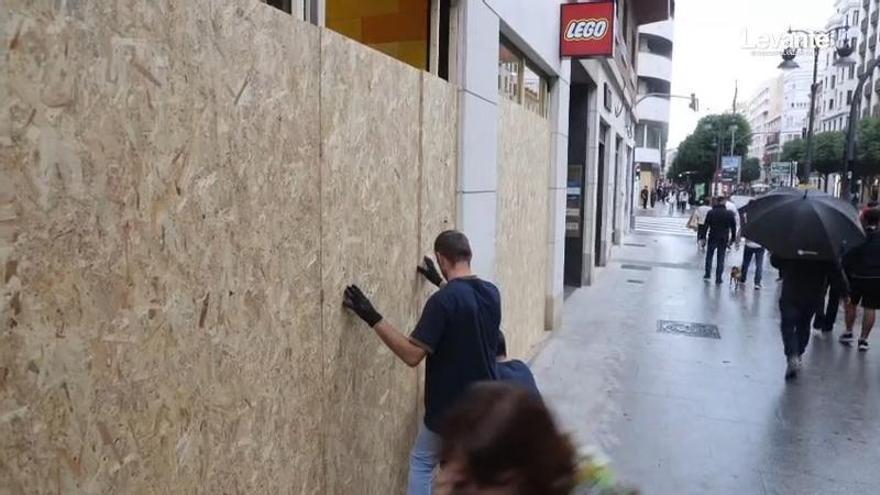 Tiendas blindadas con paneles de madera y chapa y establecimientos cerrados por la amenaza de saqueos en València