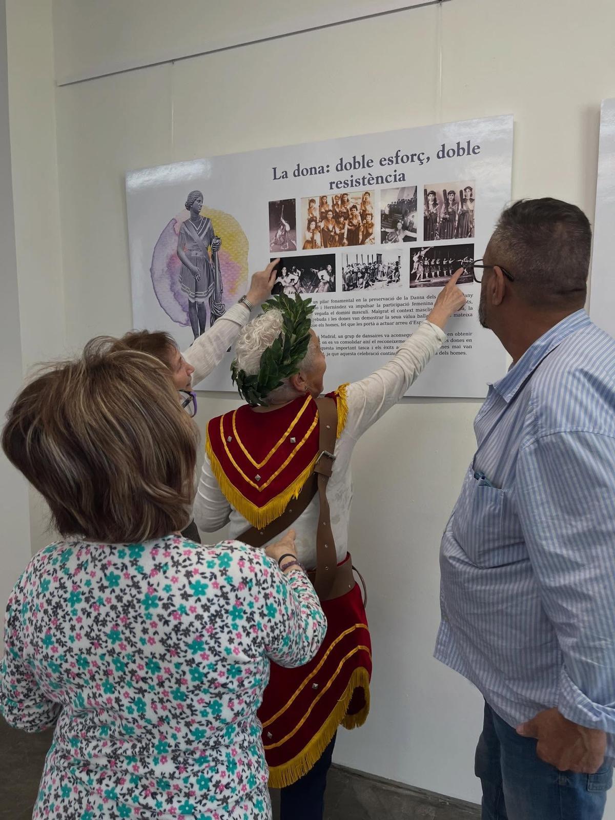 Una de las primeras ballaoras señala una foto antigua donde aparece en la exposición.