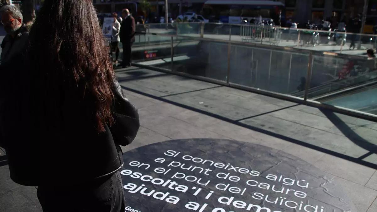 Una jove llegeix un missatge d'una campanya de Salut contra el suicïdi