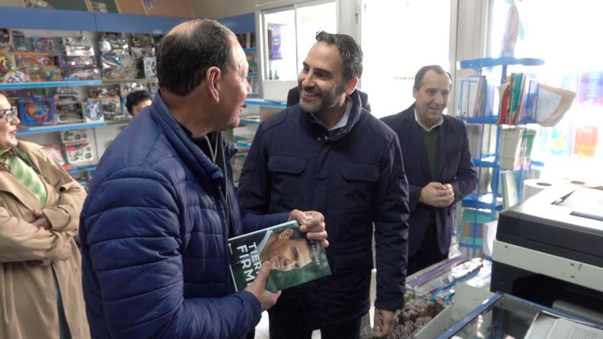 Dani Pérez le regala al portavoz del PSOE en Humilladero, Miguel Asencio, el libro de Pedro Sánchez en una librería del pueblo.