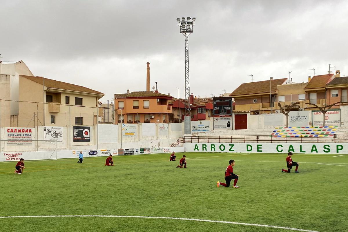 Los jugadores del Calasparra y Lorquí, arrodillados antes del encuentro