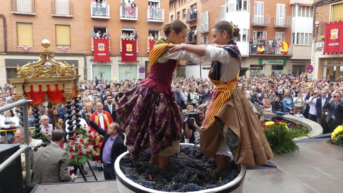 Dos jóvenes de Encinacorba, Andrea Patricia Azobo y Carlota Gascón, pisan las uvas en la fuente de La Mora, donde sale vino en vez de agua.