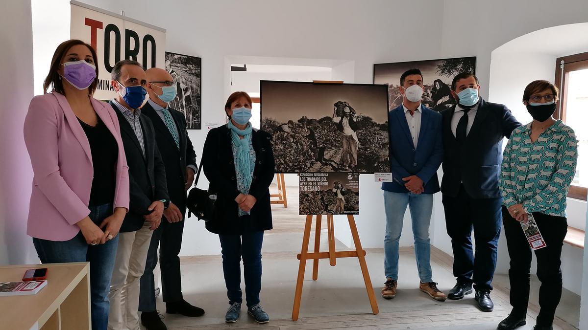 Fortuoso y De La Torre, junto al cartel promocional de la muestra, posan con autoridades en el Alcázar